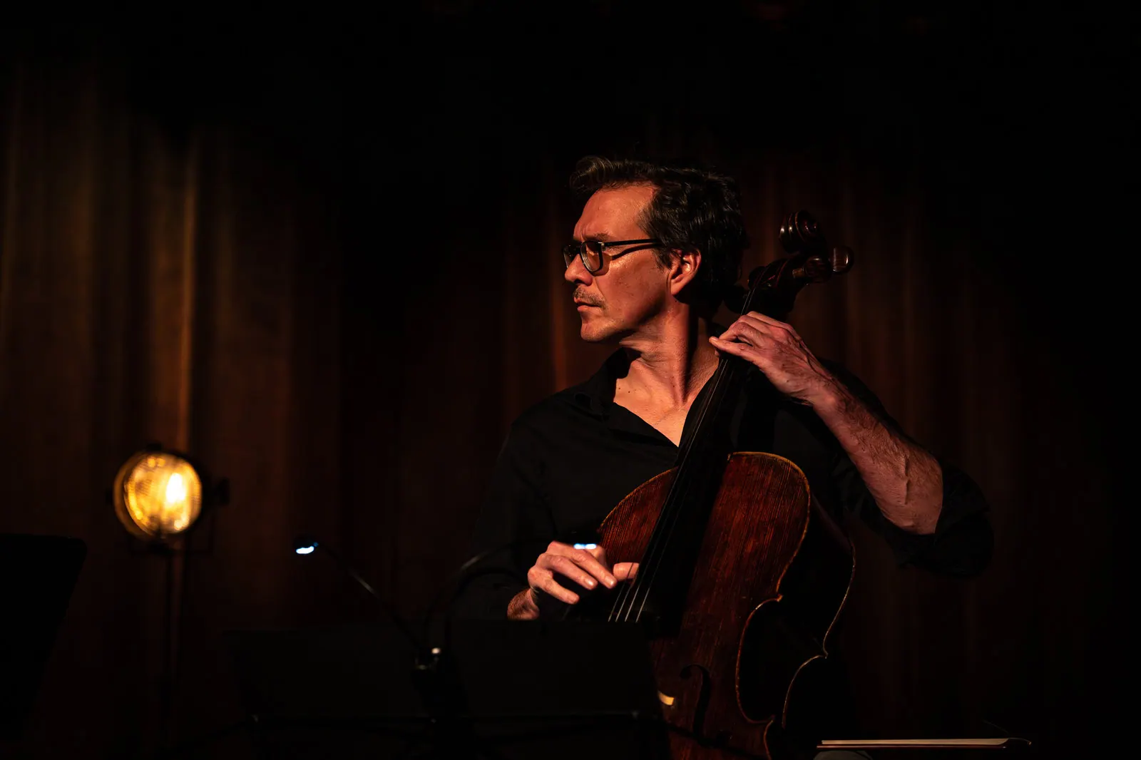 Cellist im dunklen Bühnenlicht